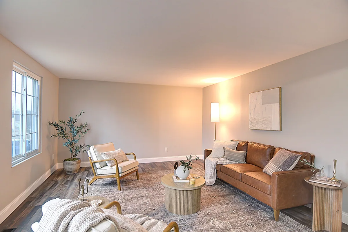 Renovated Huber Heights living room after EZ Sell Homebuyers — clean greige walls, luxury vinyl plank floors, neutral staging, open feel