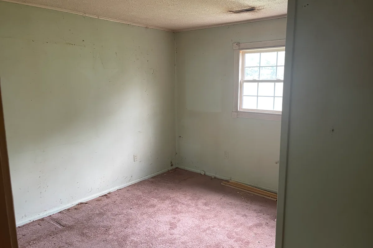 Fairborn Florence Avenue bedroom before sale — mint green smudged walls, stained pink carpet, dated double-hung window