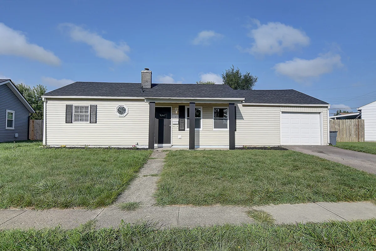 Same Fairborn ranch on Florence Avenue after EZ Sell Homebuyers renovation — fresh paint, sharp black accent trim, manicured lawn, refreshed curb appeal