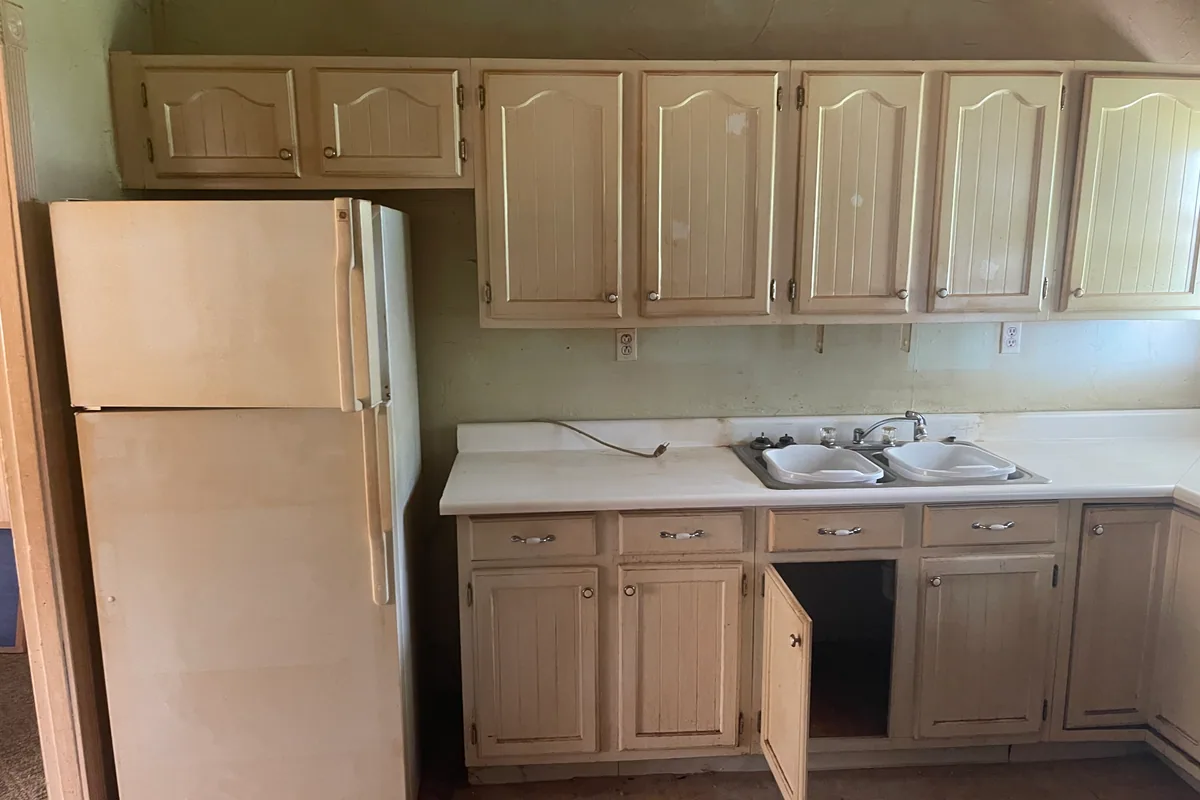 Fairborn Florence Avenue kitchen before EZ Sell Homebuyers cash purchase — original 1960s knotty arched cabinets, chipped double sink, dated white refrigerator