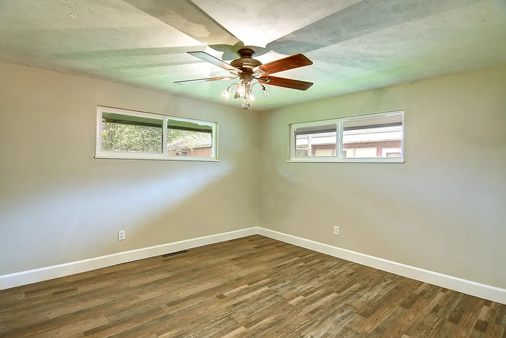 Renovated Kettering bedroom — neutral paint, ceiling fan, fresh trim, new luxury vinyl plank flooring