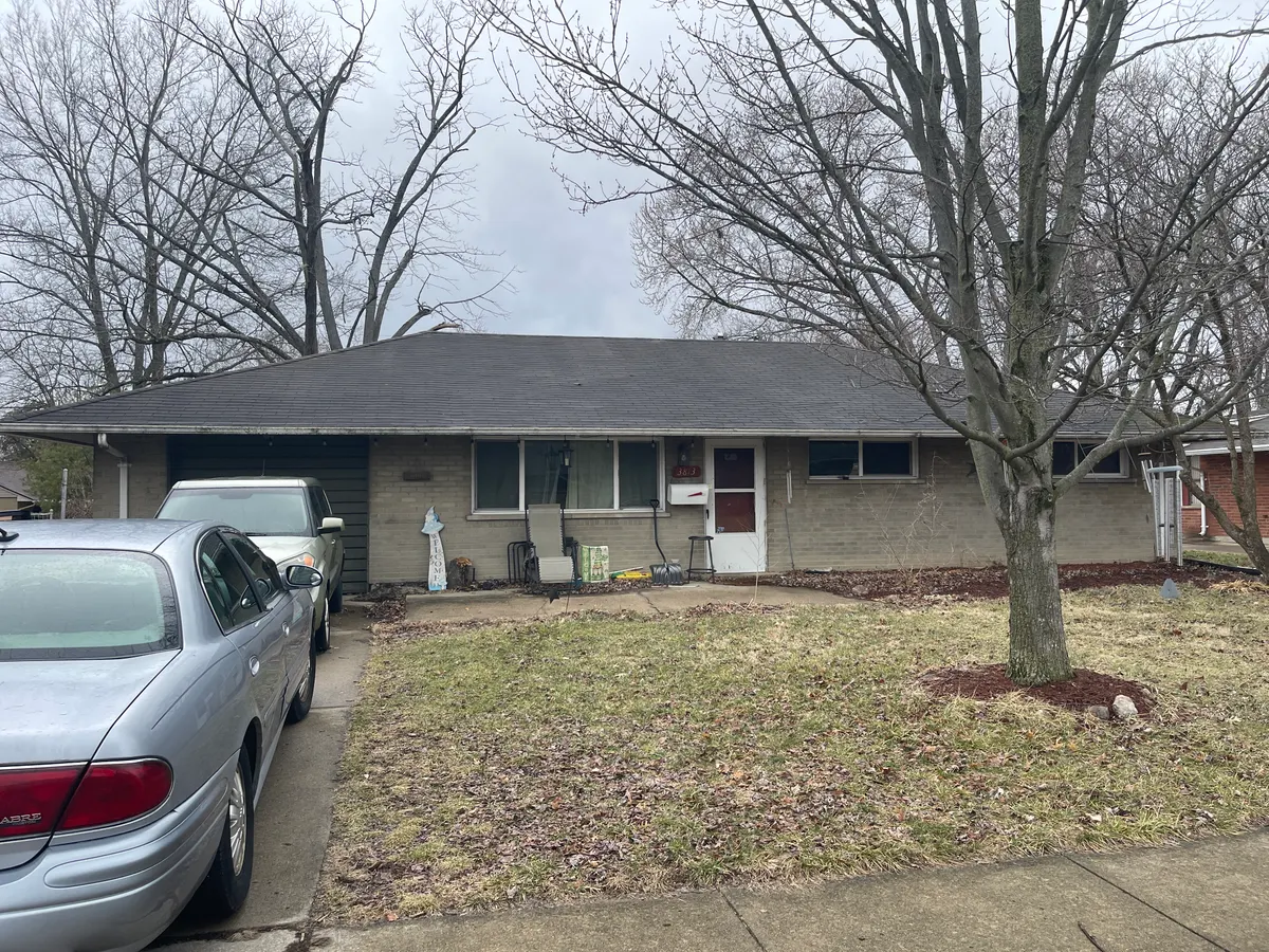 Kettering Utica Drive brick ranch before cash sale to EZ Sell Homebuyers — winter exterior with cluttered driveway and bare trees