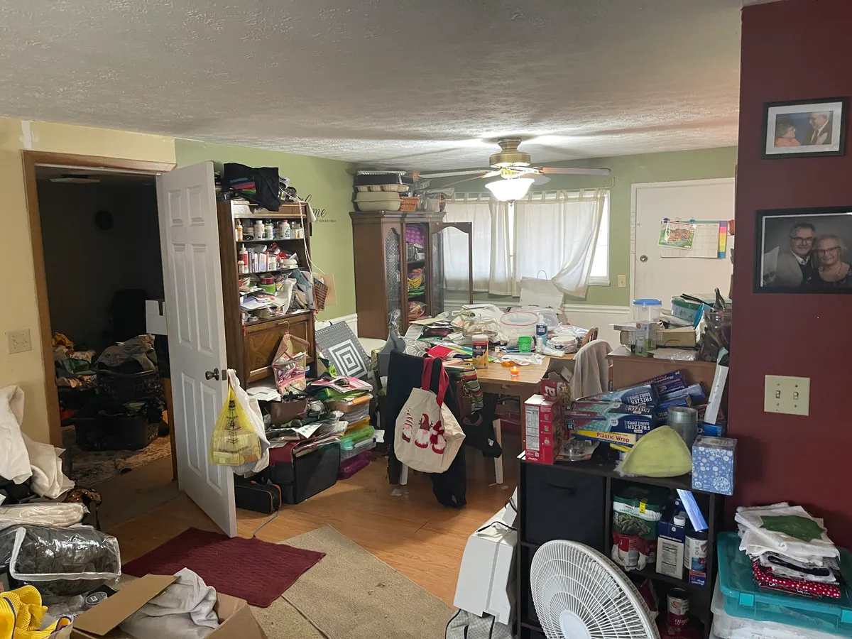 Kettering Utica Drive great room before sale — overwhelmed with belongings, china cabinets full, dated wall color
