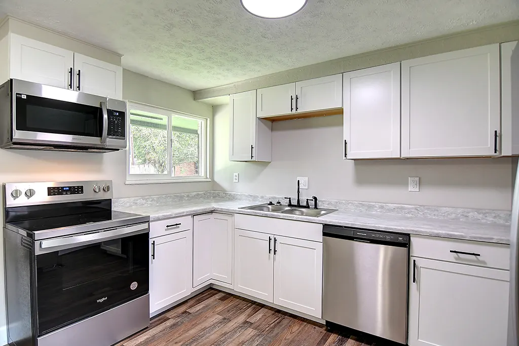 Renovated Kettering kitchen after EZ Sell Homebuyers — white shaker cabinets, stainless appliances, modern lighting, new countertops