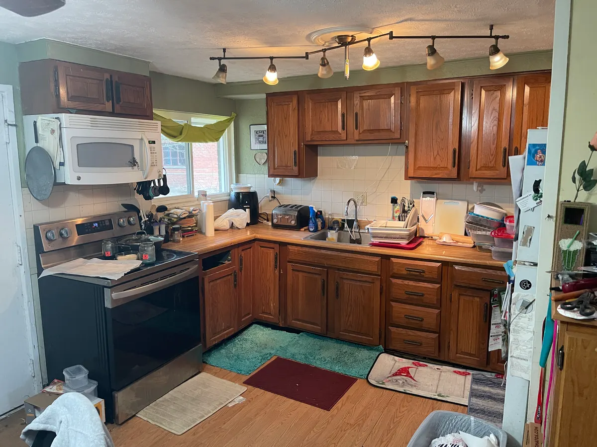 Kettering Utica Drive kitchen before EZ Sell Homebuyers cash purchase — original 1970s oak cabinets, track lights, dated appliances