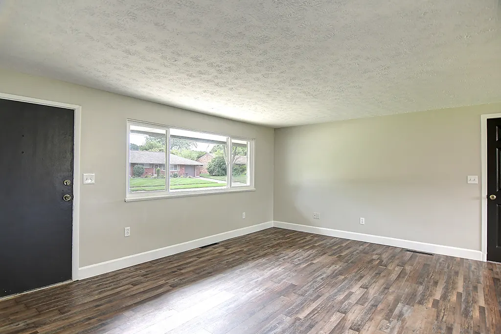 Renovated Kettering living room after EZ Sell Homebuyers — bright neutral paint, new luxury vinyl plank floors, large picture window