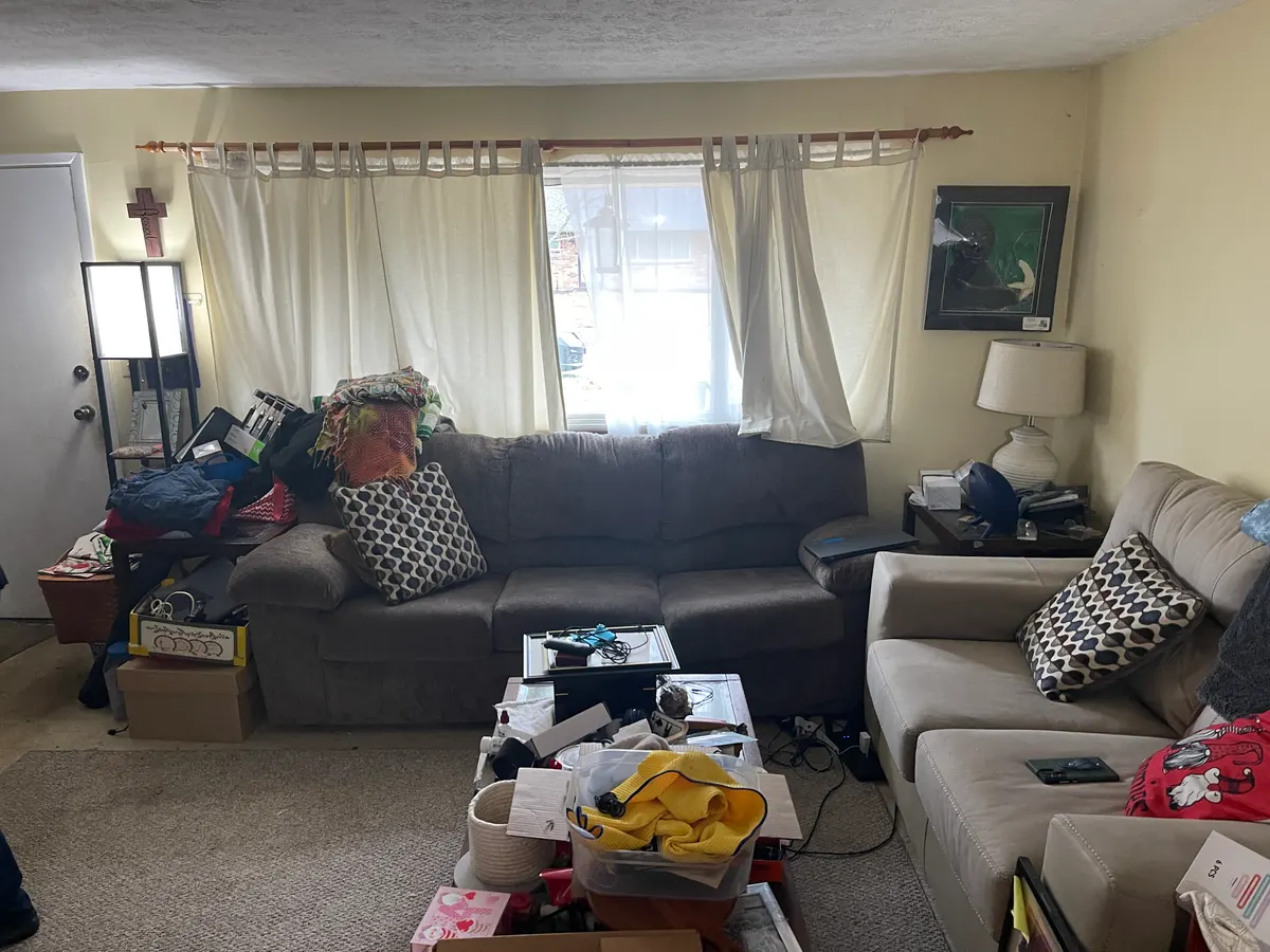 Kettering ranch living room before sale — cluttered with furniture, family belongings, dim lighting, dated curtains
