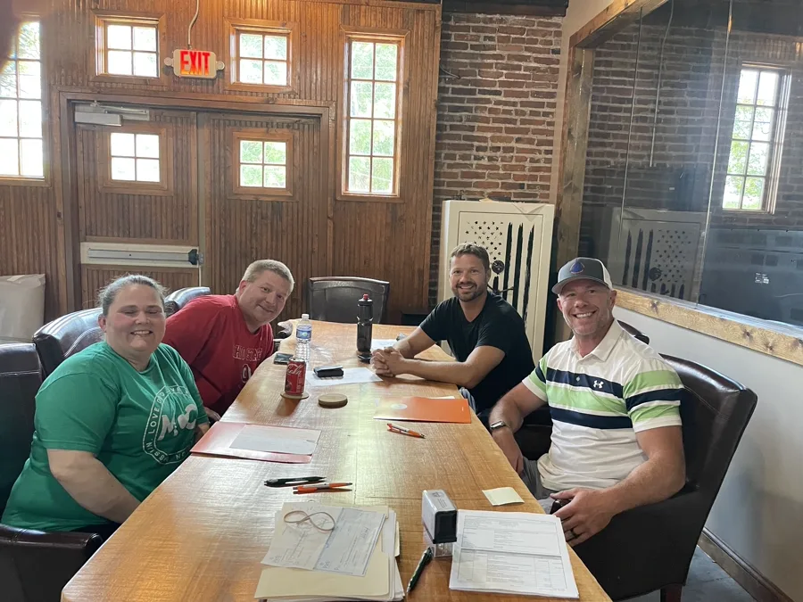 Happy sellers signing closing paperwork with Mike Wall at EZ Sell Homebuyers — Dayton, OH